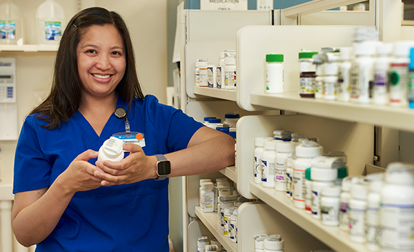 A UIC College of Pharmacy student poses for a photo in the College's pharmacy.